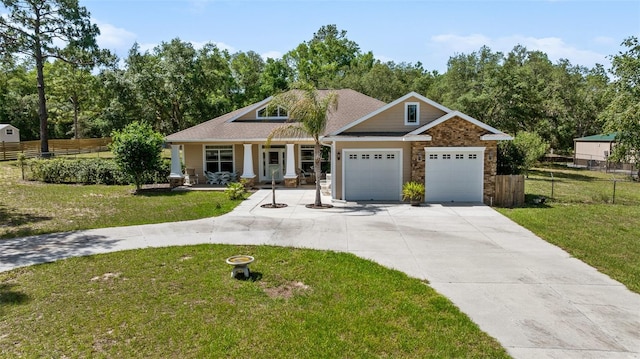 2948 W Henley Ln, Dunnellon, FL 34433 - craftsman inspired home featuring covered porch, concrete driveway, an attached garage, stone siding, and a shingled roof