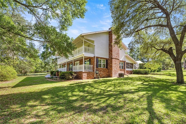20861 SW 81st Loop, Dunnellon, FL 34431 - back of house featuring brick siding, a yard, a balcony, and central air condition unit