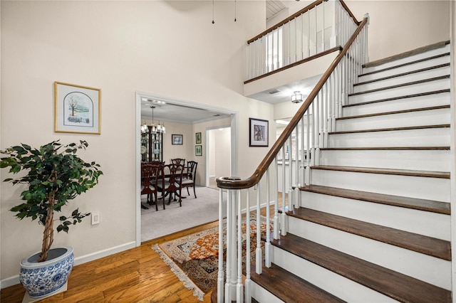 20861 SW 81st Loop, Dunnellon, FL 34431 - stairs featuring baseboards, wood finished floors, a chandelier, and a high ceiling