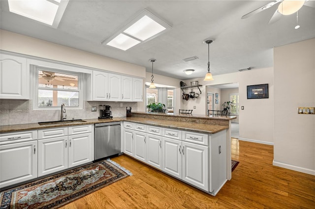 20861 SW 81st Loop, Dunnellon, FL 34431 - kitchen with dishwasher, a sink, a peninsula, backsplash, and light wood-style flooring