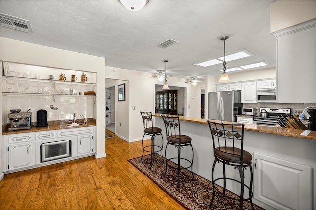 20861 SW 81st Loop, Dunnellon, FL 34431 - kitchen featuring stainless steel appliances, a peninsula, decorative backsplash, ceiling fan, and a sink