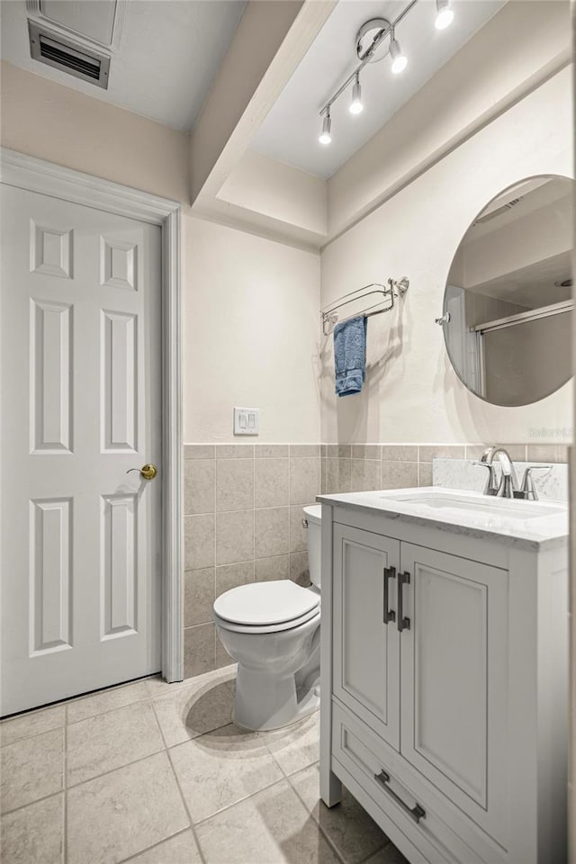 20861 SW 81st Loop, Dunnellon, FL 34431 - full bathroom with tile walls, vanity, toilet, wainscoting, and tile patterned floors