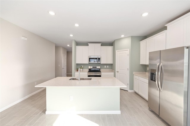1875 NW 44 Court Rd, Ocala, FL 34482 - kitchen featuring stainless steel appliances, a sink, a kitchen island with sink, baseboards, and light countertops