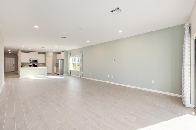 1875 NW 44 Court Rd, Ocala, FL 34482 - unfurnished living room featuring baseboards, recessed lighting, and light wood finished floors