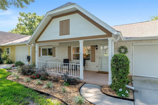 view of front of home featuring a porch, a shingled roof, and stone siding