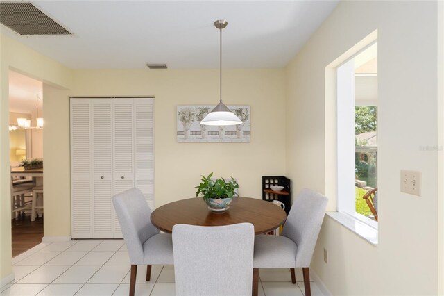 dining room with a chandelier, baseboards, and light tile patterned flooring