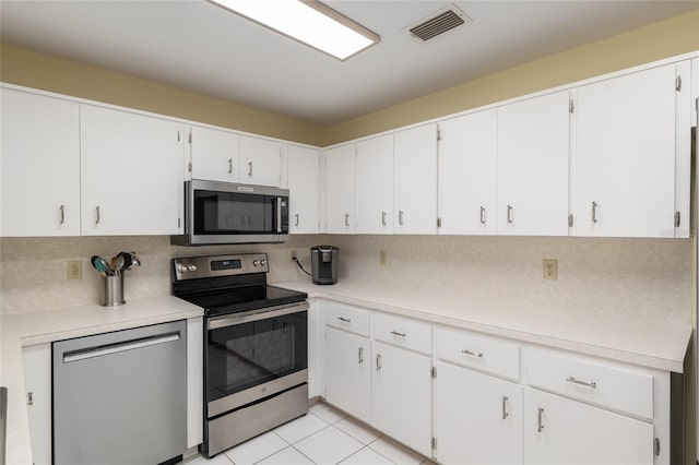 kitchen with stainless steel appliances, tasteful backsplash, light countertops, and white cabinetry