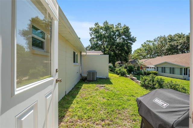 view of grassy yard featuring central AC unit