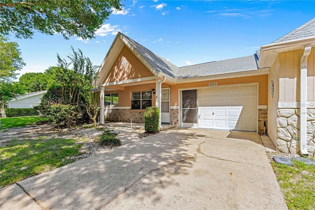 view of front of home featuring concrete driveway, an attached garage, stone siding, a porch, and roof with shingles