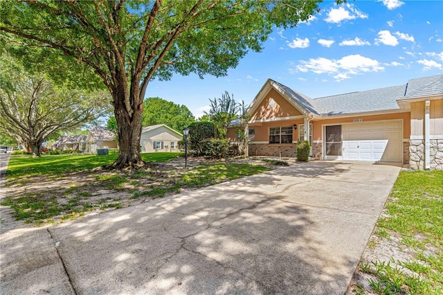 view of front of home featuring an attached garage, concrete driveway, stone siding, and stucco siding