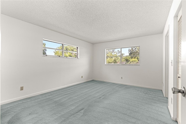 unfurnished bedroom with carpet floors, a textured ceiling, and baseboards
