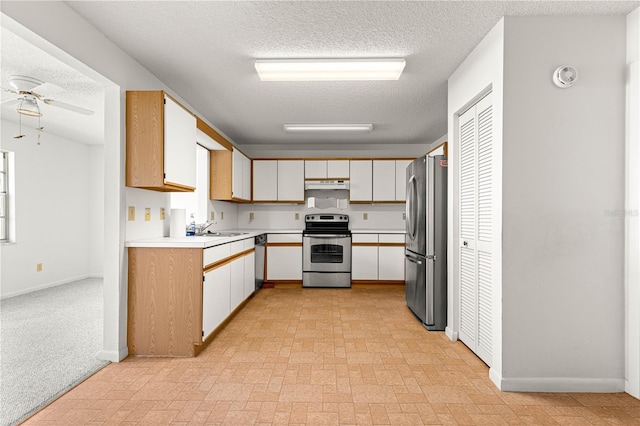kitchen with appliances with stainless steel finishes, under cabinet range hood, ceiling fan, a textured ceiling, and light countertops