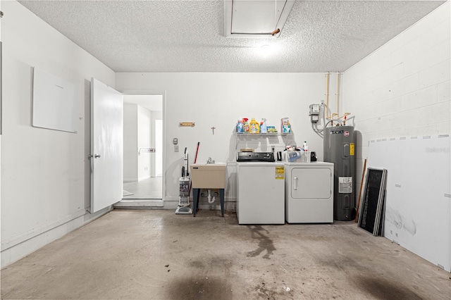 garage featuring washer and clothes dryer, electric water heater, concrete block wall, and a sink