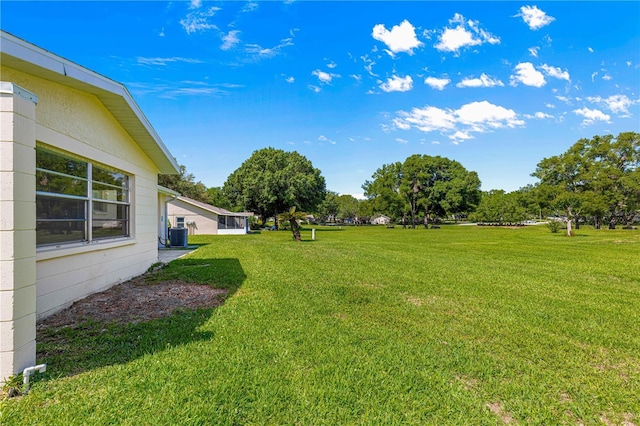 view of grassy yard featuring central air condition unit