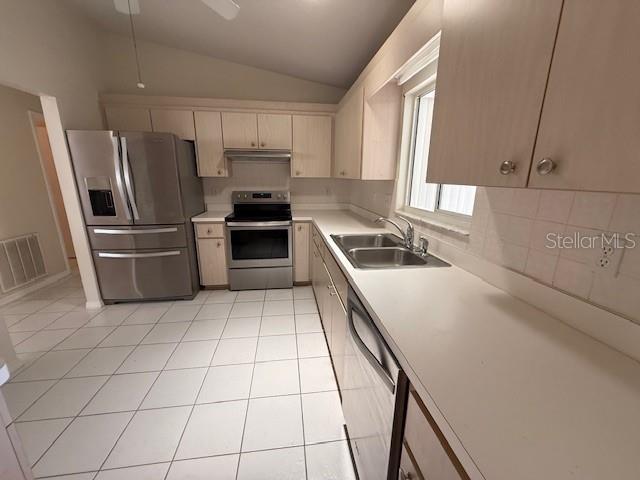 17522 SE 96th Ct, Summerfield, FL 34491 - kitchen featuring stainless steel appliances, light countertops, lofted ceiling, under cabinet range hood, and light tile patterned floors