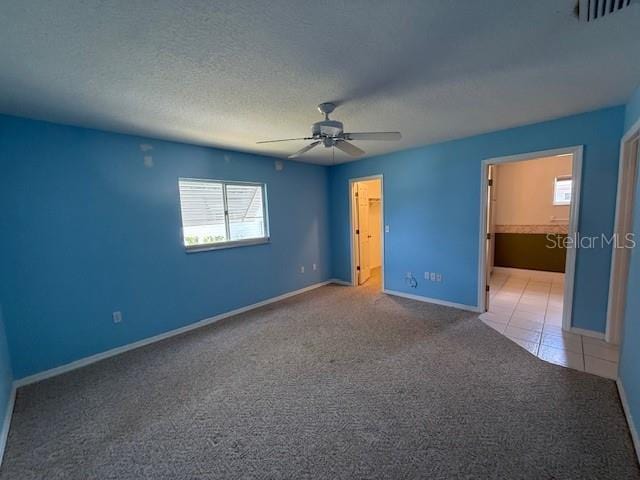 17522 SE 96th Ct, Summerfield, FL 34491 - unfurnished bedroom featuring light colored carpet, a spacious closet, a closet, a ceiling fan, and ensuite bathroom