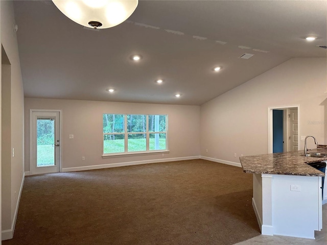 unfurnished living room with a sink, dark colored carpet, baseboards, recessed lighting, and lofted ceiling
