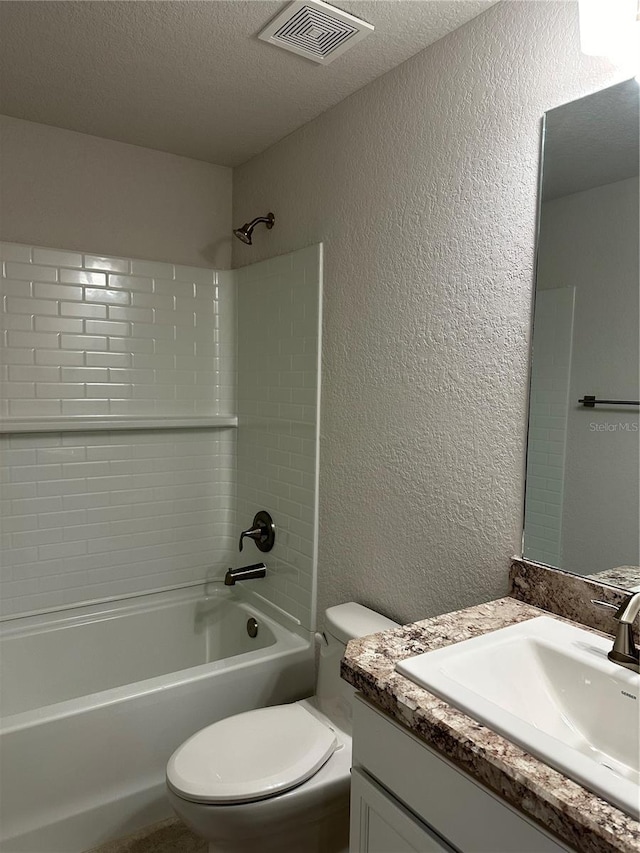 full bath featuring a textured wall, toilet, tub / shower combination, a textured ceiling, and vanity