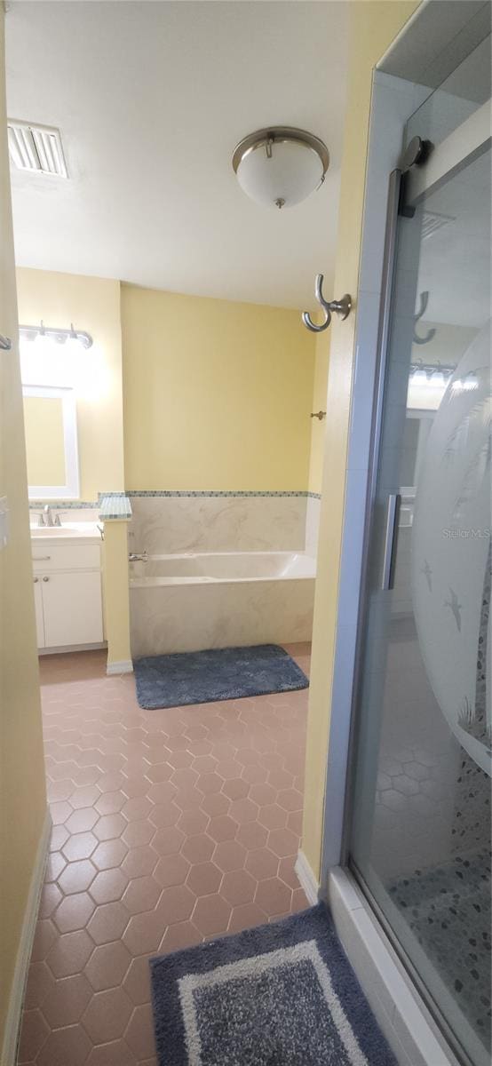 3891 N Grapefern Way, Beverly Hills, FL 34465 - bathroom featuring a stall shower, a bath, vanity, and tile patterned flooring