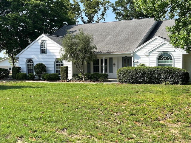 view of front of house with a front lawn and roof with shingles
