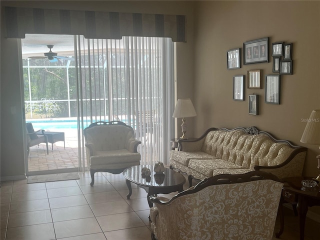 living area with a ceiling fan and tile patterned flooring