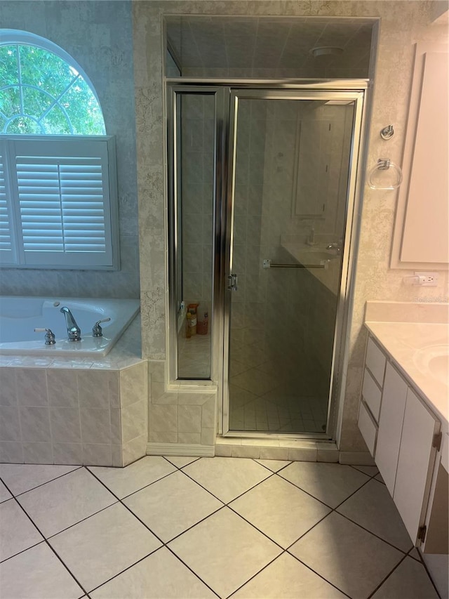 bathroom with a garden tub, tile patterned floors, a stall shower, and vanity