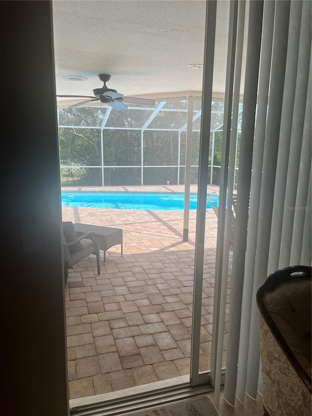 swimming pool featuring a patio and glass enclosure