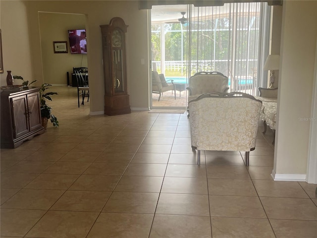 living room featuring healthy amount of natural light, light tile patterned floors, and baseboards
