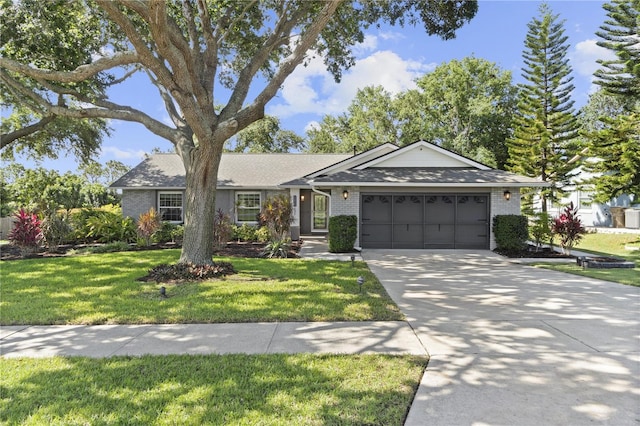 ranch-style house featuring an attached garage, driveway, a front lawn, brick siding, and a shingled roof