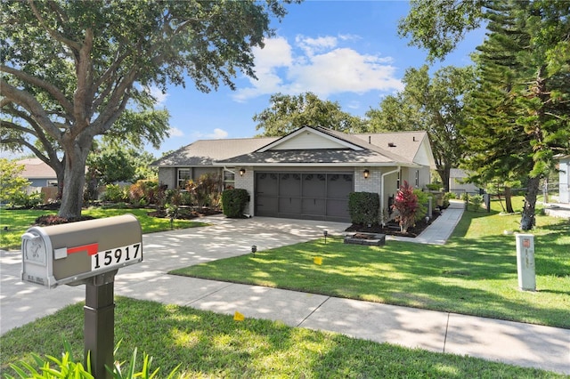 ranch-style home with an attached garage, concrete driveway, brick siding, and a front lawn