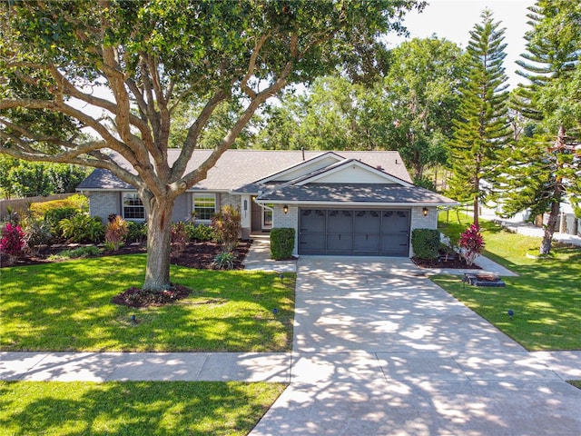 ranch-style home with an attached garage, concrete driveway, a front lawn, brick siding, and a shingled roof