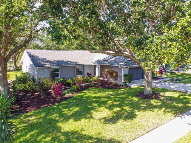 ranch-style house with driveway, a garage, a front yard, and a shingled roof