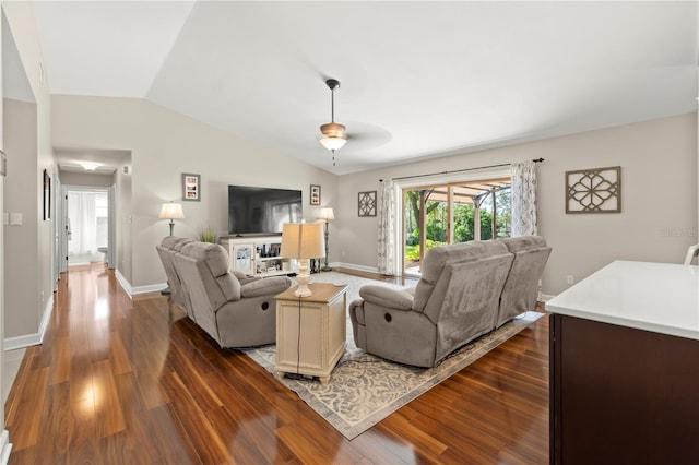 living area featuring lofted ceiling, dark wood-type flooring, and baseboards