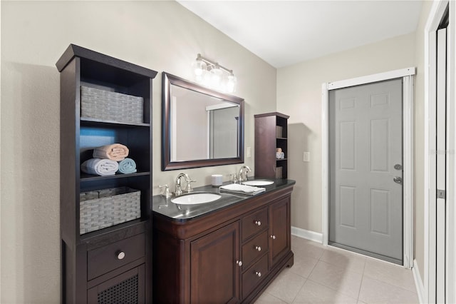 bathroom featuring tile patterned floors, baseboards, and double vanity