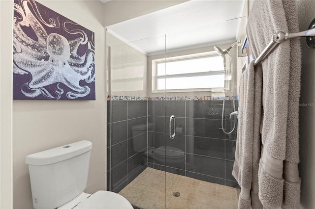 bathroom featuring toilet, a shower stall, and crown molding