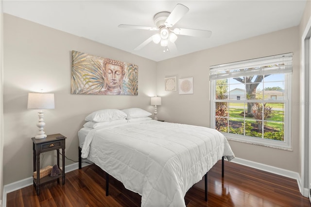 bedroom featuring baseboards, wood finished floors, and ceiling fan