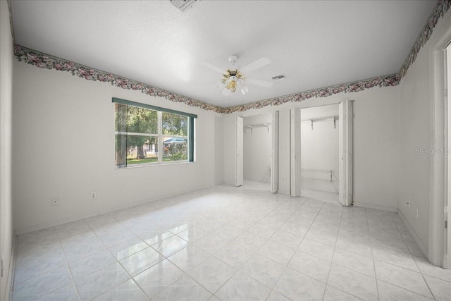 4992 NW 31st St, Ocala, FL 34482 - unfurnished bedroom featuring ceiling fan, multiple closets, and baseboards