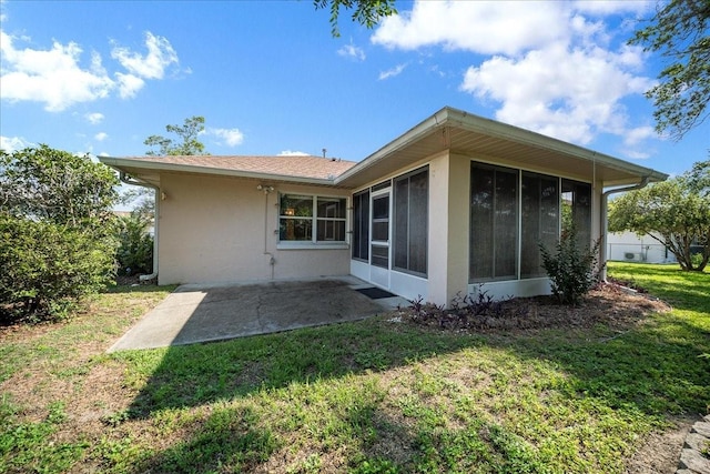 4992 NW 31st St, Ocala, FL 34482 - back of property with a sunroom, stucco siding, a patio area, and a lawn