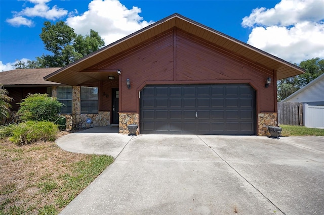 23 Larch Crse, Ocala, FL 34480 - view of front facade with stone siding, a garage, driveway, and fence