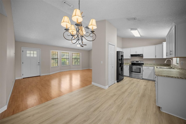 23 Larch Crse, Ocala, FL 34480 - kitchen with stainless steel range with electric cooktop, black fridge, a sink, vaulted ceiling, and open floor plan