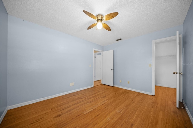 23 Larch Crse, Ocala, FL 34480 - unfurnished bedroom featuring wood finished floors, a textured ceiling, baseboards, a spacious closet, and a closet