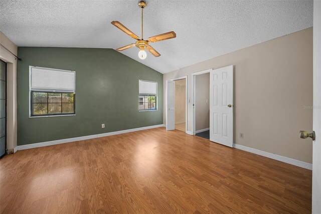 23 Larch Crse, Ocala, FL 34480 - unfurnished bedroom featuring a textured ceiling, wood finished floors, vaulted ceiling, ceiling fan, and baseboards