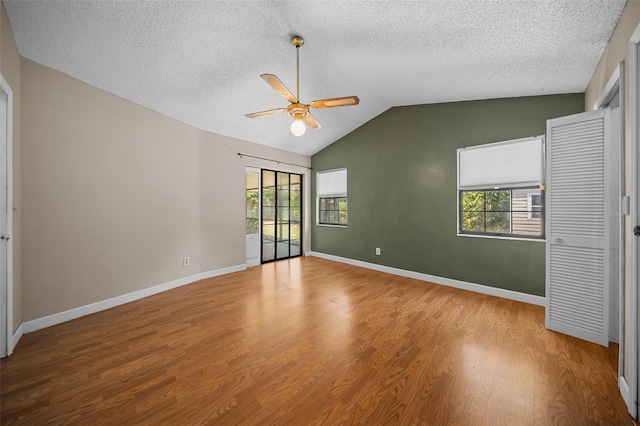 23 Larch Crse, Ocala, FL 34480 - unfurnished bedroom with multiple windows, wood finished floors, a textured ceiling, vaulted ceiling, and ceiling fan