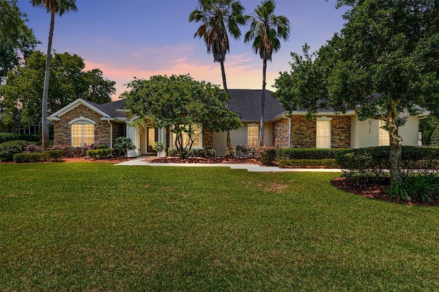 view of front of property featuring stone siding and a lawn