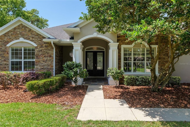 property entrance featuring stone siding and french doors