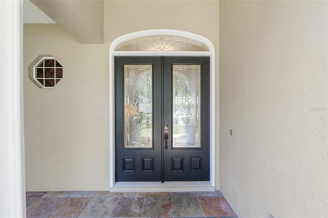 property entrance with french doors and stucco siding