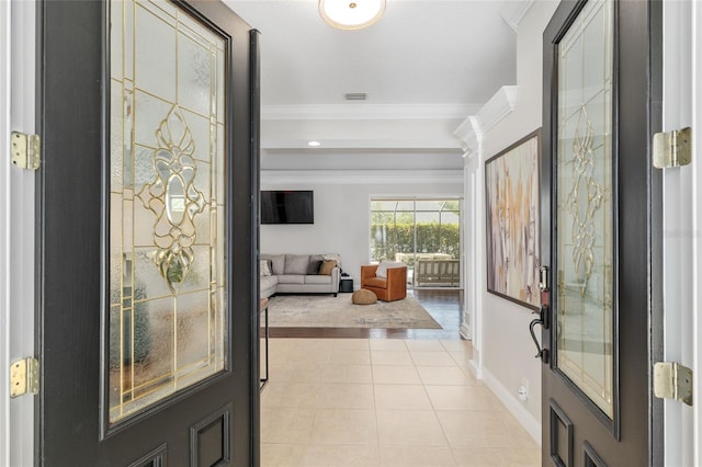 foyer entrance featuring crown molding, baseboards, and light tile patterned floors