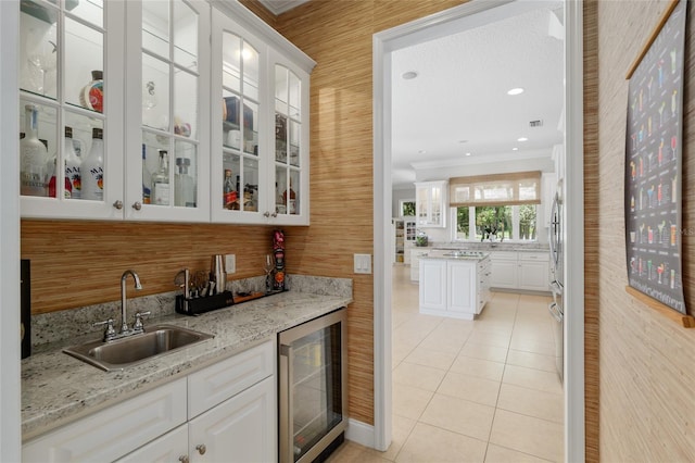 indoor wet bar featuring beverage cooler, crown molding, light tile patterned floors, and backsplash