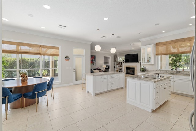 kitchen with a kitchen island, crown molding, healthy amount of natural light, open floor plan, and light tile patterned flooring