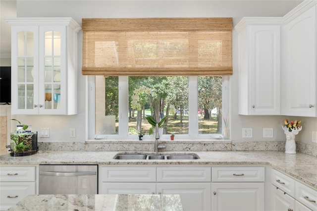 kitchen with stainless steel dishwasher, glass insert cabinets, white cabinets, and healthy amount of natural light